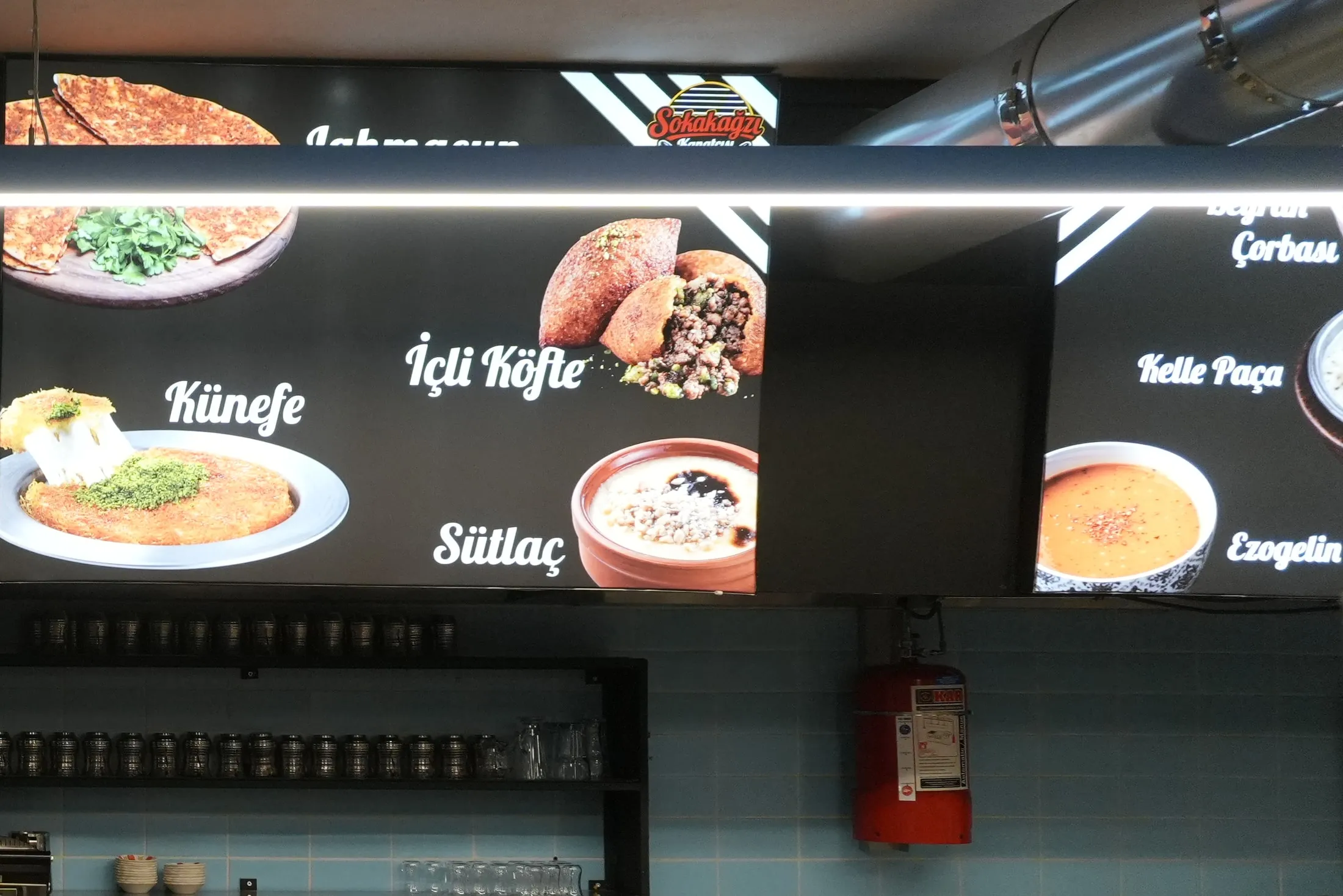 Restoranın iç mekânındaki ışıklı menü panoları ve servis tezgâhı